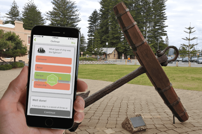 Shipwrecks Play Trails App Mockup_hand_background_wider