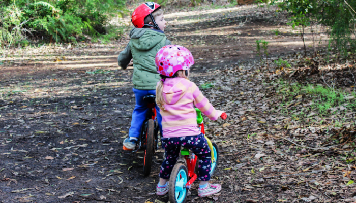 a couple of children riding bikes