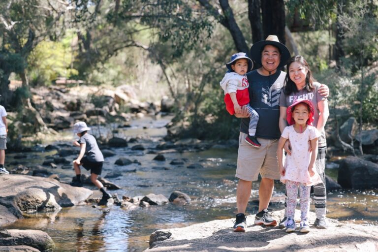 A family smile for a photo on a rock near a brook in John Forrest National Park.